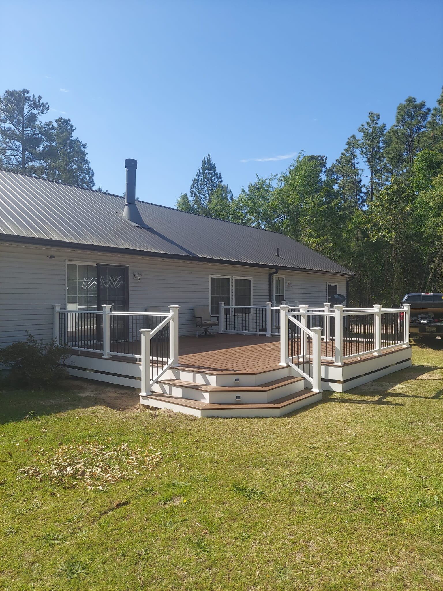 Completed modern deck with white posts and black metal railings
